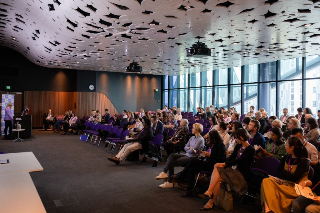 The Bone Marrow Failure Symposium audience watching CEO Amy Coote speaking from the lectern at the VCC